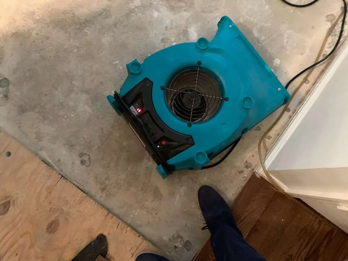 Air mover drying subfloor during Commercial Water Damage Restoration in Athol